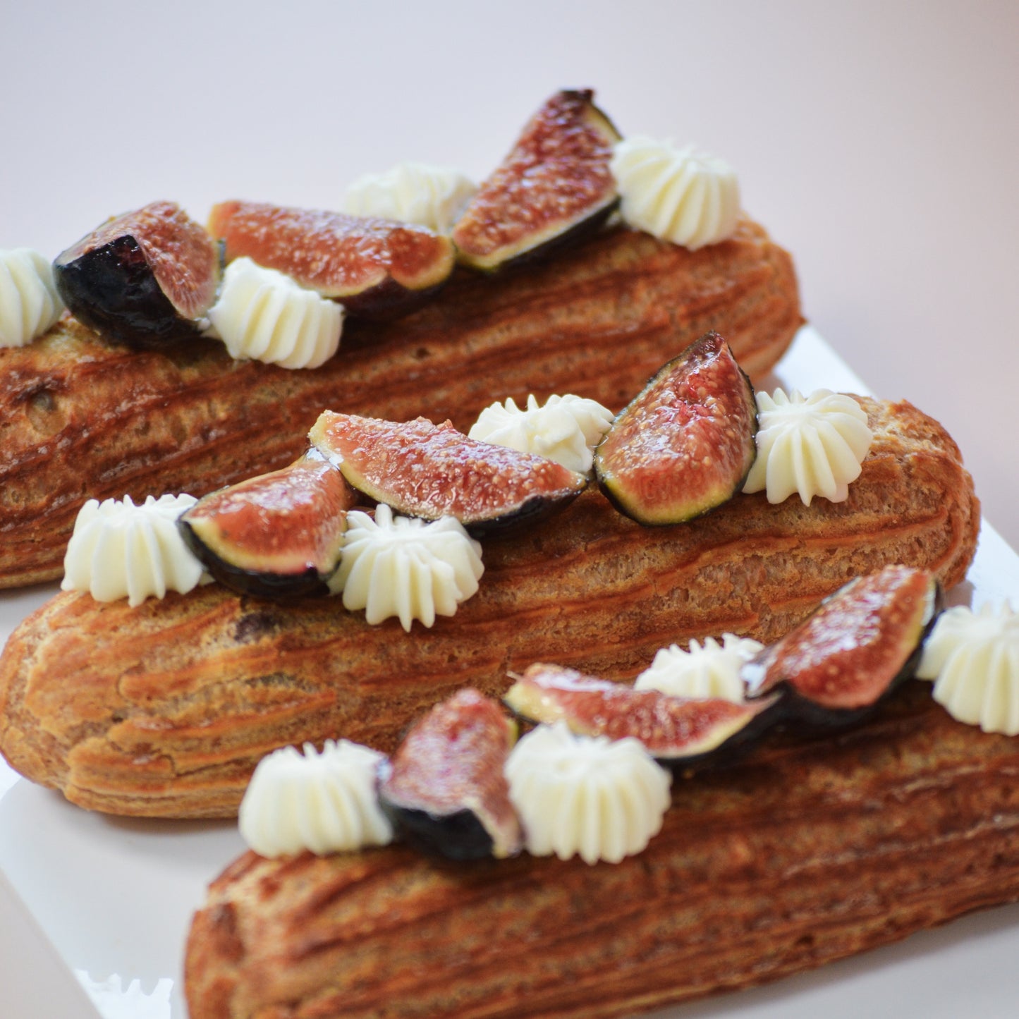 Éclair de higo con queso de cabra en corte, mostrando relleno de mermelada de higo y crema de queso de cabra.